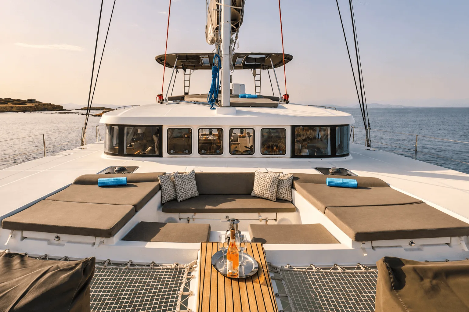 Foredeck lounge of a sailing catamaran with cushions on the trampoline
