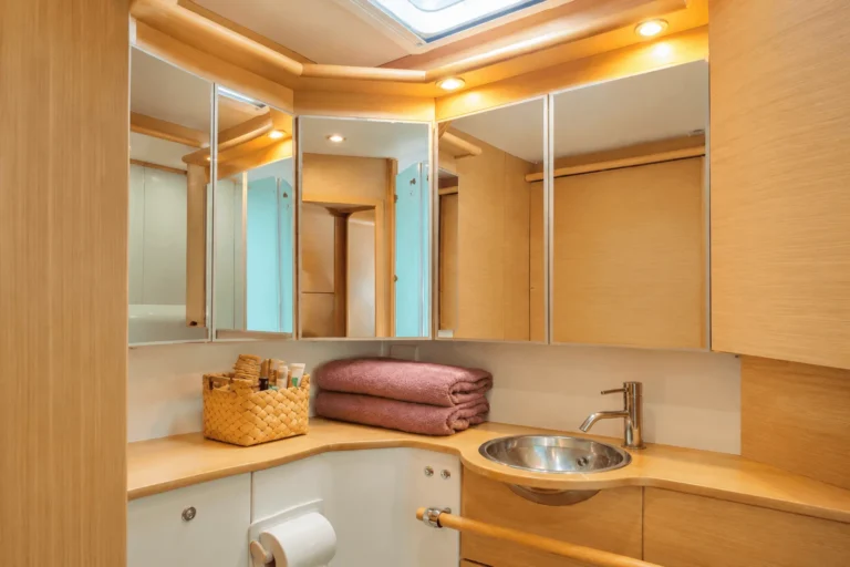 The heads compartment of a sailing catamaran with a washbasin and folded towels